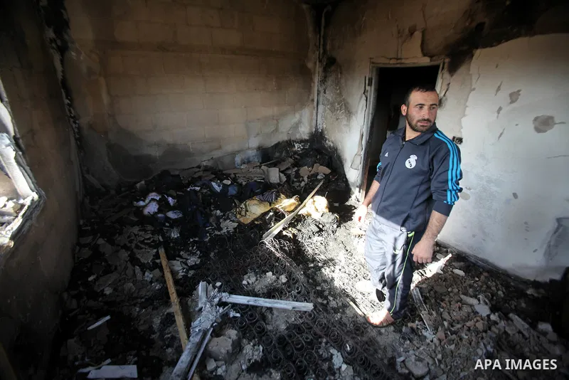 Palestinians inspect a damaged house following a blaze overnight in the village of Duma in the Israeli-occupied West Bank on July 20, 2016. The house is located in the Palestinian village where an arson attack by Jewish...