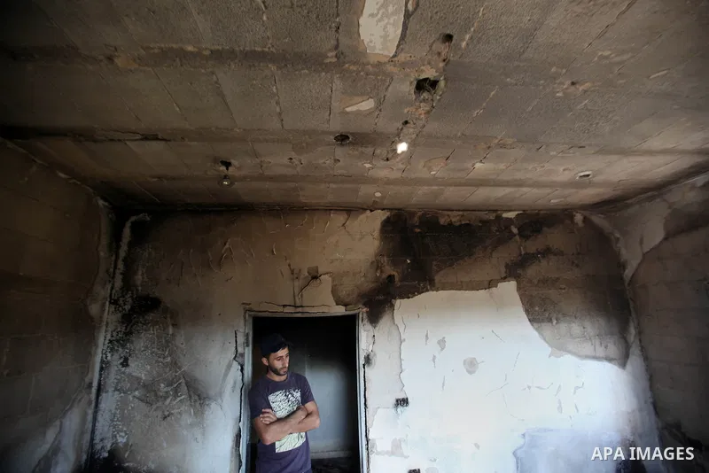 Palestinians inspect a damaged house following a blaze overnight in the village of Duma in the Israeli-occupied West Bank on July 20, 2016. The house is located in the Palestinian village where an arson attack by Jewish...
