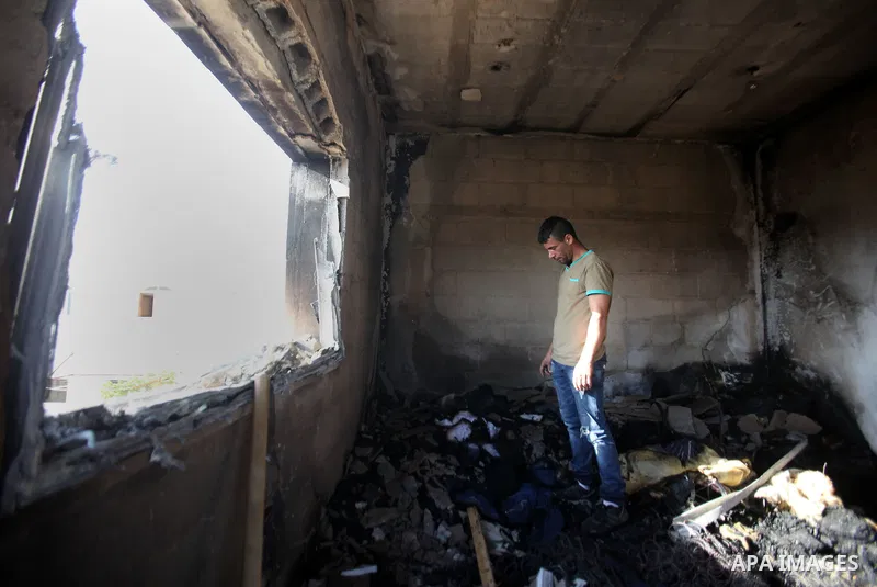 Palestinians inspect a damaged house following a blaze overnight in the village of Duma in the Israeli-occupied West Bank on July 20, 2016. The house is located in the Palestinian village where an arson attack by Jewish...