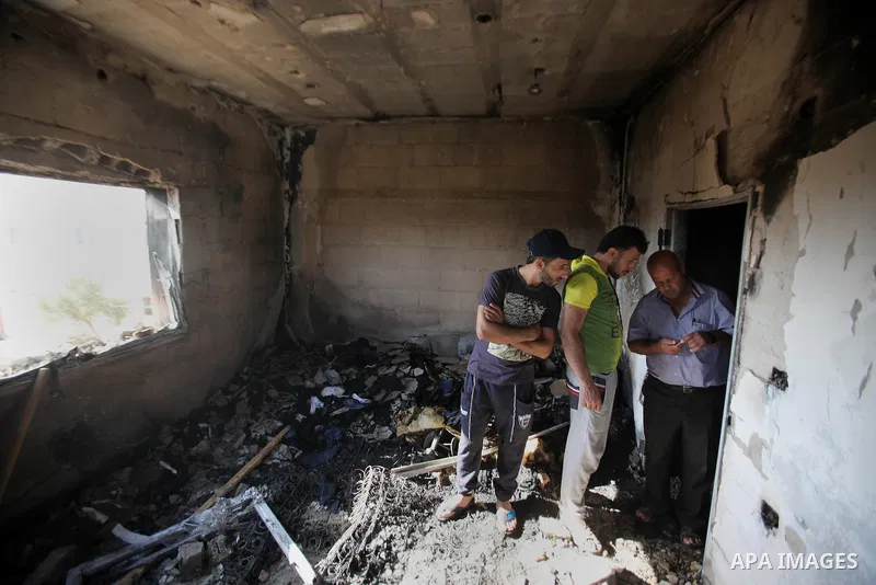 Palestinians inspect a damaged house following a blaze overnight in the village of Duma in the Israeli-occupied West Bank on July 20, 2016. The house is located in the Palestinian village where an arson attack by Jewish...