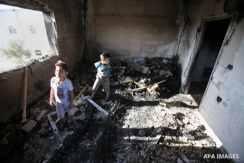 Palestinians inspect a damaged house following a blaze overnight in the village of Duma in the Israeli-occupied West Bank on July 20, 2016. The house is located in the Palestinian village where an arson attack by Jewish...