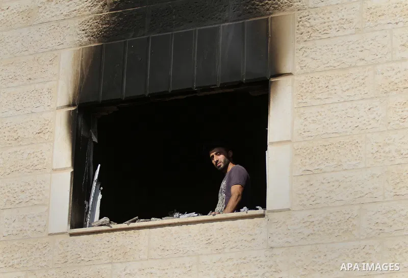 Palestinians inspect a damaged house following a blaze overnight in the village of Duma in the Israeli-occupied West Bank on July 20, 2016. The house is located in the Palestinian village where an arson attack by Jewish...