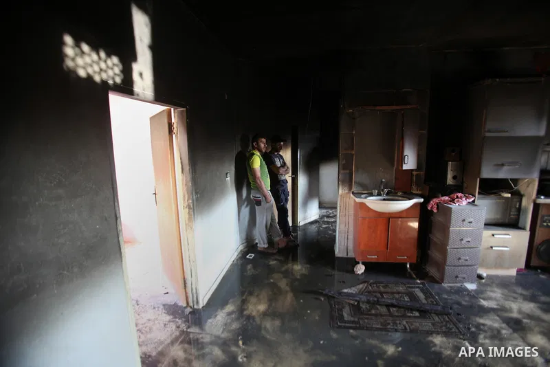 Palestinians inspect a damaged house following a blaze overnight in the village of Duma in the Israeli-occupied West Bank on July 20, 2016. The house is located in the Palestinian village where an arson attack by Jewish...