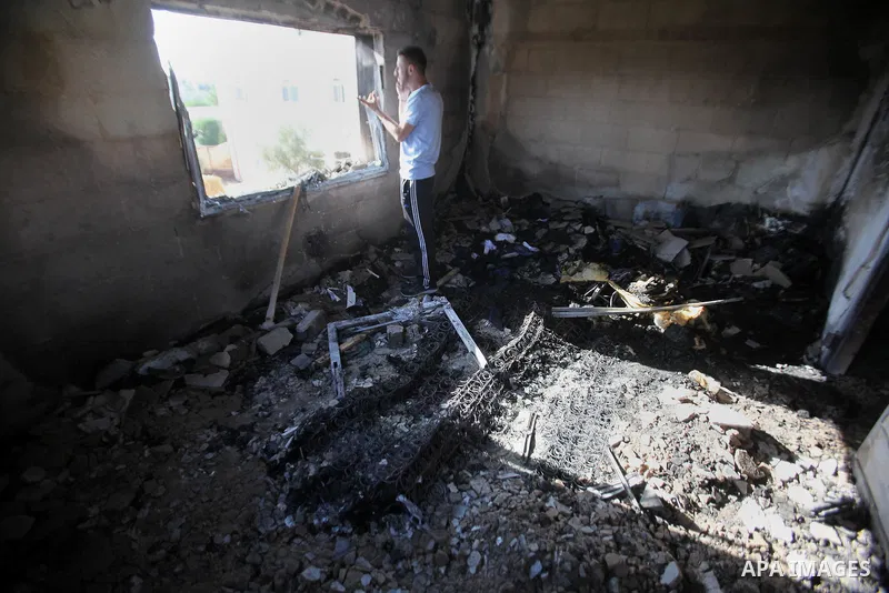 Palestinians inspect a damaged house following a blaze overnight in the village of Duma in the Israeli-occupied West Bank on July 20, 2016. The house is located in the Palestinian village where an arson attack by Jewish...