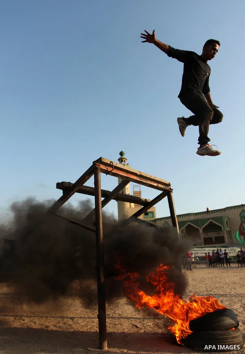 Palestinian youths demonstrate their skills during a military-style exercise at the Liberation Youths summer camp, organised by the Hamas movement, in Gaza city on July 20, 2016. Photo by Ashraf Amra