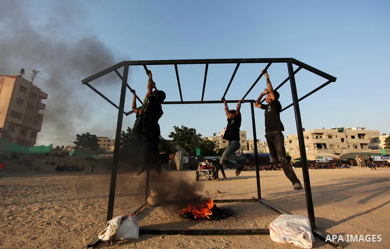 Palestinian youths demonstrate their skills during a military-style exercise at the Liberation Youths summer camp, organised by the Hamas movement, in Gaza city on July 20, 2016. Photo by Ashraf Amra