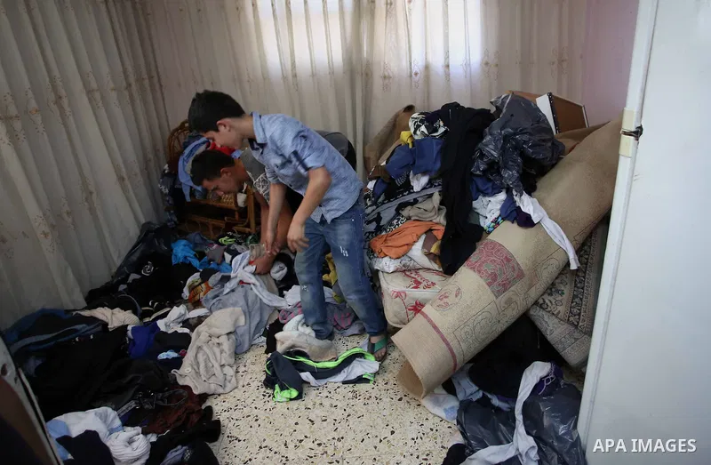 Palestinians inspect their room after the Israeli soldiers raided their family house, at Kafr Qalil village near the West Bank city of Nablus, on July 21, 2016. Photo by Nedal Eshtayah