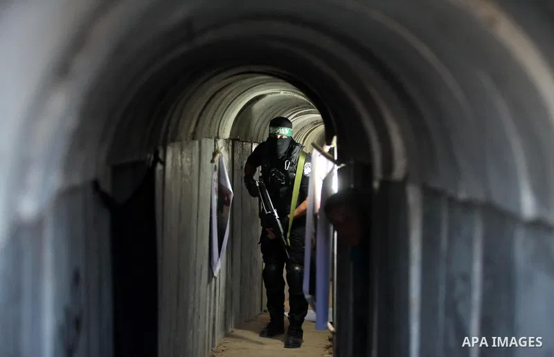 A member of the Ezzedine al-Qassam Brigades, the military wing of the Palestinian Islamist movement Hamas, walks inside a tunnel used for military exercises during a weapon exhibition at a Hamas-run youth summer camp, in...
