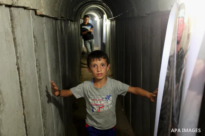 Palestinians walk inside a tunnel used for military exercises during a weapon exhibition at a Hamas-run youth summer camp, in Gaza City, on July 21, 2016. Photo by Ashraf Amra