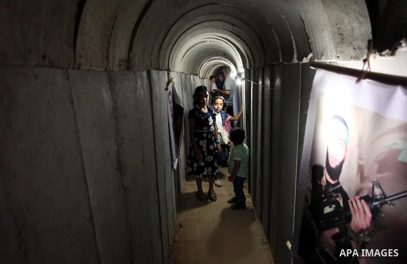 Palestinians walk inside a tunnel used for military exercises during a weapon exhibition at a Hamas-run youth summer camp, in Gaza City, on July 21, 2016. Photo by Ashraf Amra