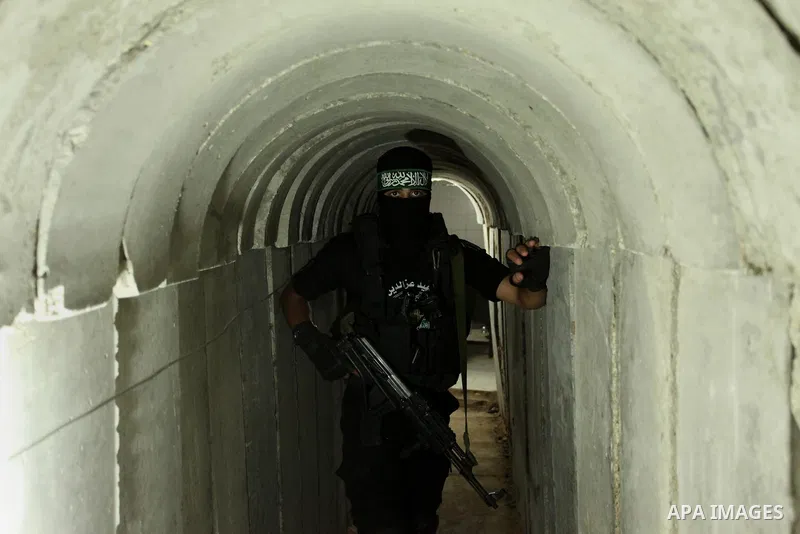 A member of the Ezzedine al-Qassam Brigades, the military wing of the Palestinian Islamist movement Hamas, walks inside a tunnel used for military exercises during a weapon exhibition at a Hamas-run youth summer camp, in...