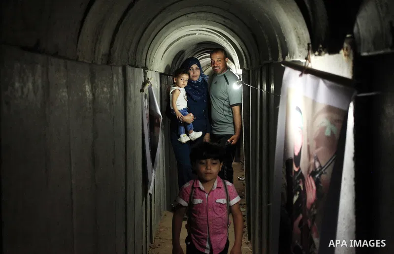Palestinians walk inside a tunnel used for military exercises during a weapon exhibition at a Hamas-run youth summer camp, in Gaza City, on July 21, 2016. Photo by Ashraf Amra