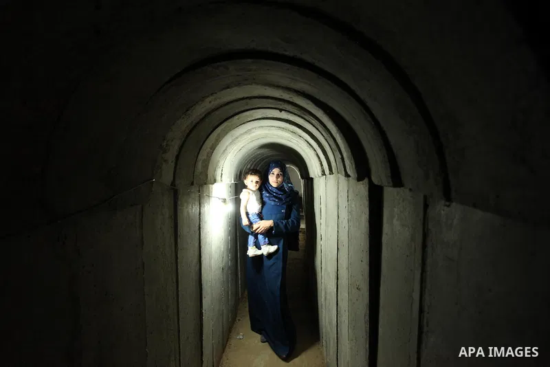 A Palestinian woman walks inside a tunnel used for military exercises during a weapon exhibition at a Hamas-run youth summer camp, in Gaza City, on July 21, 2016. Photo by Ashraf Amra