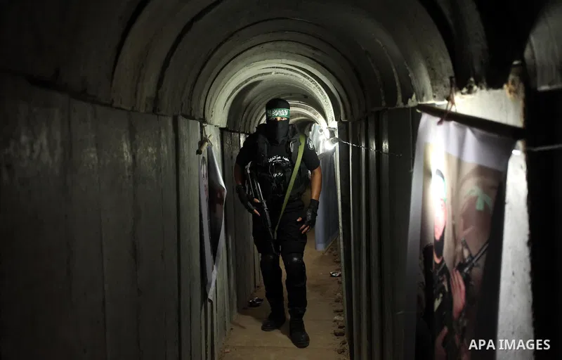 A member of the Ezzedine al-Qassam Brigades, the military wing of the Palestinian Islamist movement Hamas, walks inside a tunnel used for military exercises during a weapon exhibition at a Hamas-run youth summer camp, in...