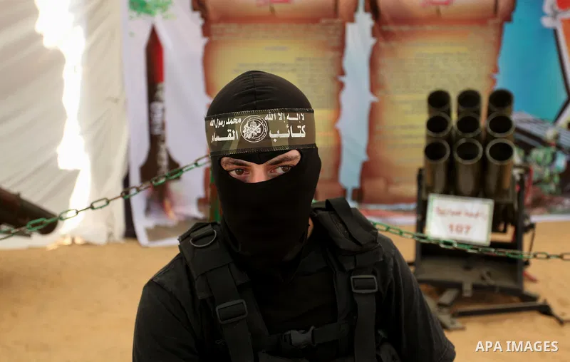 A member of the Ezzedine al-Qassam Brigades, the military wing of the Palestinian Islamist movement Hamas poses for a photographer during a weapon exhibition at a Hamas-run youth summer camp, in Gaza City, on July 21, 20...