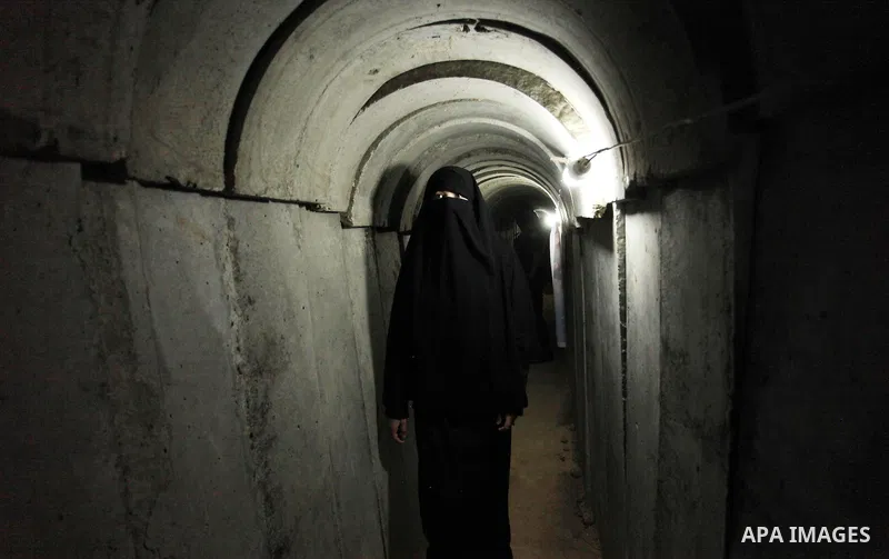 A Palestinian woman walks inside a tunnel used for military exercises during a weapon exhibition at a Hamas-run youth summer camp, in Gaza City, on July 21, 2016. Photo by Ashraf Amra