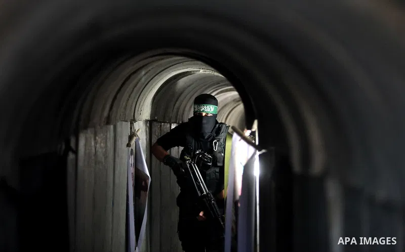 A member of the Ezzedine al-Qassam Brigades, the military wing of the Palestinian Islamist movement Hamas, walks inside a tunnel used for military exercises during a weapon exhibition at a Hamas-run youth summer camp, in...