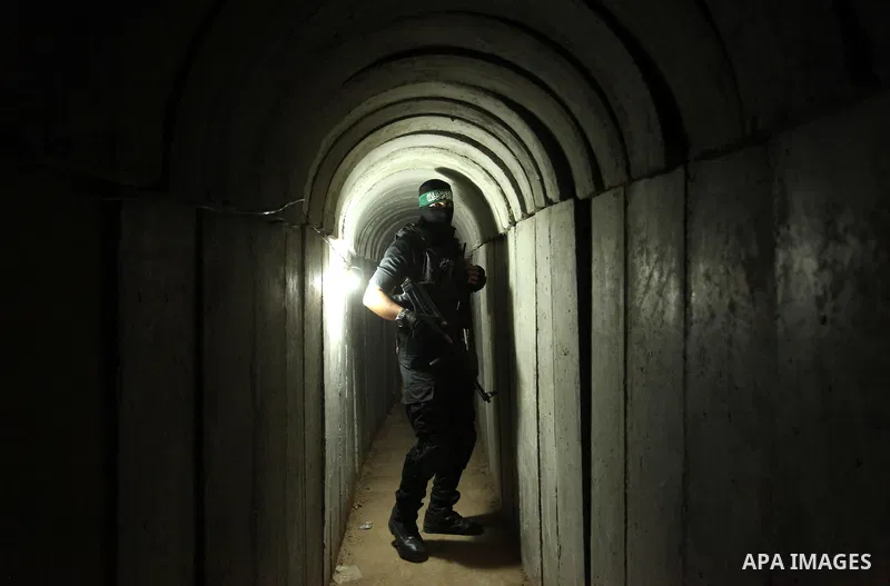 A member of the Ezzedine al-Qassam Brigades, the military wing of the Palestinian Islamist movement Hamas, walks inside a tunnel used for military exercises during a weapon exhibition at a Hamas-run youth summer camp, in...
