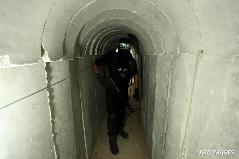 A member of the Ezzedine al-Qassam Brigades, the military wing of the Palestinian Islamist movement Hamas, walks inside a tunnel used for military exercises during a weapon exhibition at a Hamas-run youth summer camp, in...