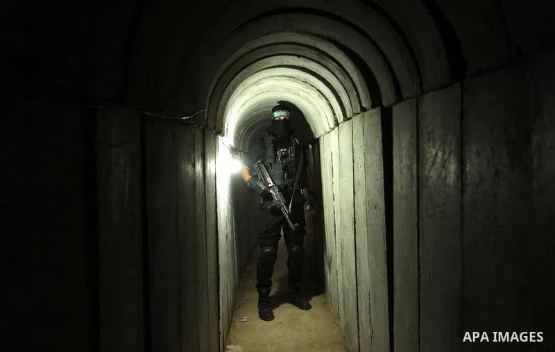 A member of the Ezzedine al-Qassam Brigades, the military wing of the Palestinian Islamist movement Hamas, walks inside a tunnel used for military exercises during a weapon exhibition at a Hamas-run youth summer camp, in...