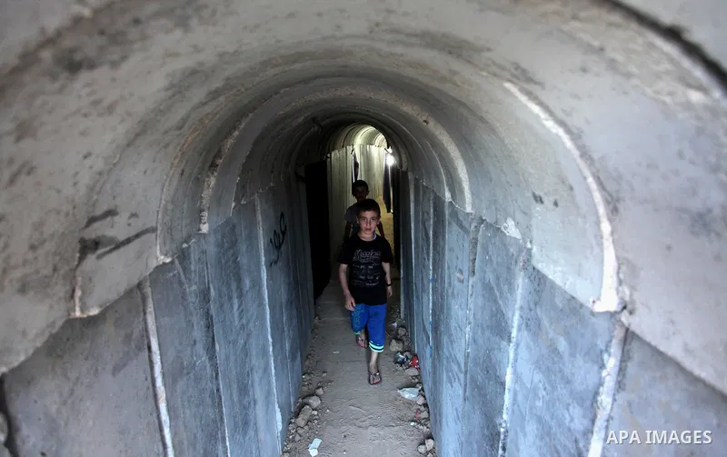 Palestinians walk inside a tunnel used for military exercises during a weapon exhibition at a Hamas-run youth summer camp, in Gaza City, on July 21, 2016. Photo by Ashraf Amra