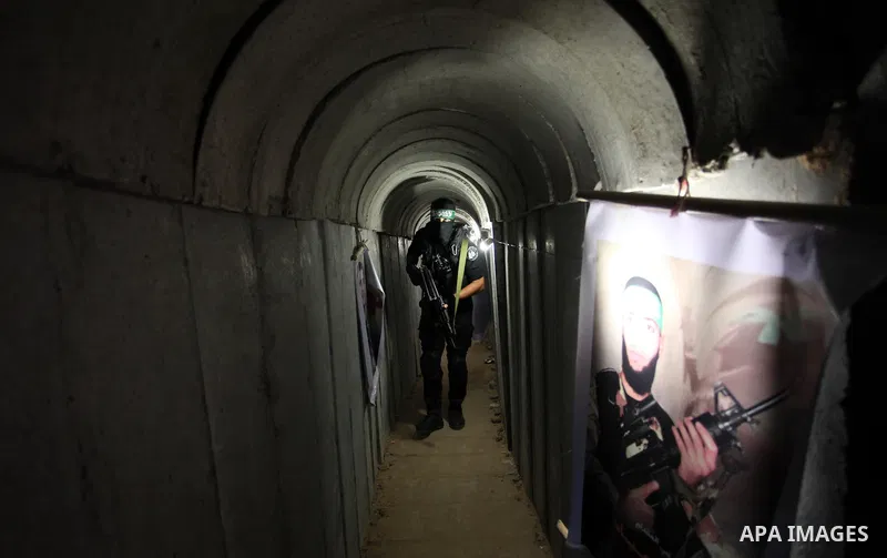 A member of the Ezzedine al-Qassam Brigades, the military wing of the Palestinian Islamist movement Hamas, walks inside a tunnel used for military exercises during a weapon exhibition at a Hamas-run youth summer camp, in...