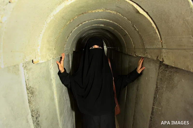 A Palestinian woman walks inside a tunnel used for military exercises during a weapon exhibition at a Hamas-run youth summer camp, in Gaza City, on July 21, 2016. Photo by Ashraf Amra