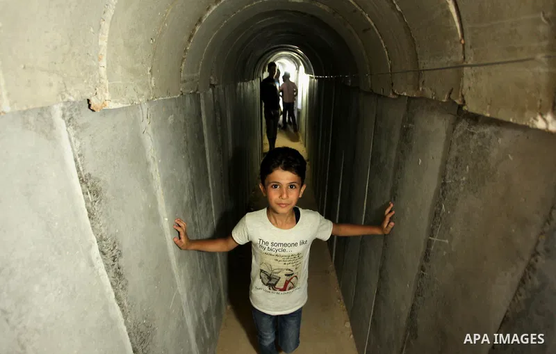 Palestinians walk inside a tunnel used for military exercises during a weapon exhibition at a Hamas-run youth summer camp, in Gaza City, on July 21, 2016. Photo by Ashraf Amra