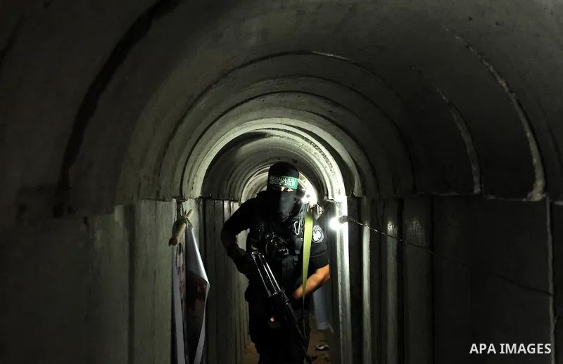 A member of the Ezzedine al-Qassam Brigades, the military wing of the Palestinian Islamist movement Hamas, walks inside a tunnel used for military exercises during a weapon exhibition at a Hamas-run youth summer camp, in...
