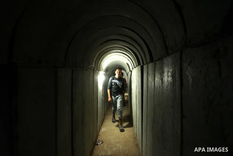 Palestinians walk inside a tunnel used for military exercises during a weapon exhibition at a Hamas-run youth summer camp, in Gaza City, on July 21, 2016. Photo by Ashraf Amra