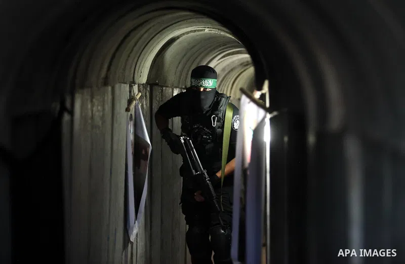 A member of the Ezzedine al-Qassam Brigades, the military wing of the Palestinian Islamist movement Hamas, walks inside a tunnel used for military exercises during a weapon exhibition at a Hamas-run youth summer camp, in...
