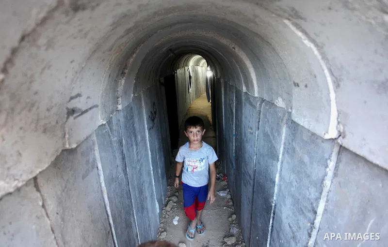 Palestinians walk inside a tunnel used for military exercises during a weapon exhibition at a Hamas-run youth summer camp, in Gaza City, on July 21, 2016. Photo by Ashraf Amra