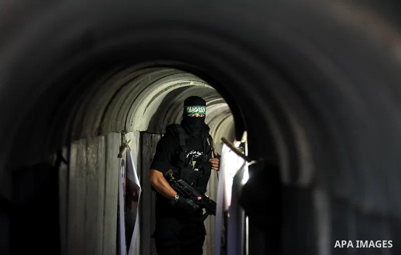A member of the Ezzedine al-Qassam Brigades, the military wing of the Palestinian Islamist movement Hamas, walks inside a tunnel used for military exercises during a weapon exhibition at a Hamas-run youth summer camp, in...
