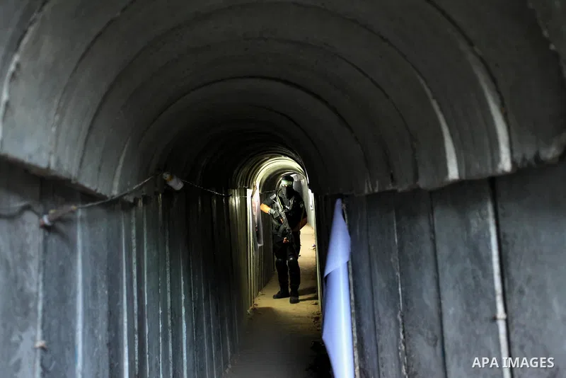 A member of the Ezzedine al-Qassam Brigades, the military wing of the Palestinian Islamist movement Hamas, walks inside a tunnel used for military exercises during a weapon exhibition at a Hamas-run youth summer camp, in...