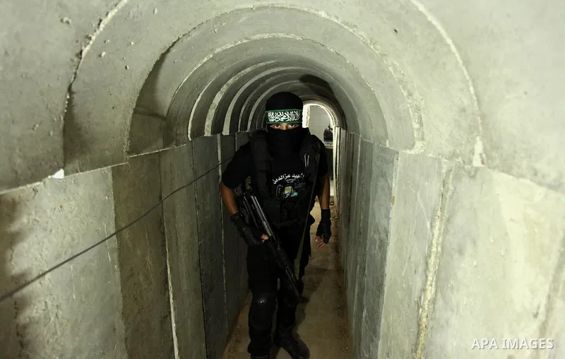 A member of the Ezzedine al-Qassam Brigades, the military wing of the Palestinian Islamist movement Hamas, walks inside a tunnel used for military exercises during a weapon exhibition at a Hamas-run youth summer camp, in...