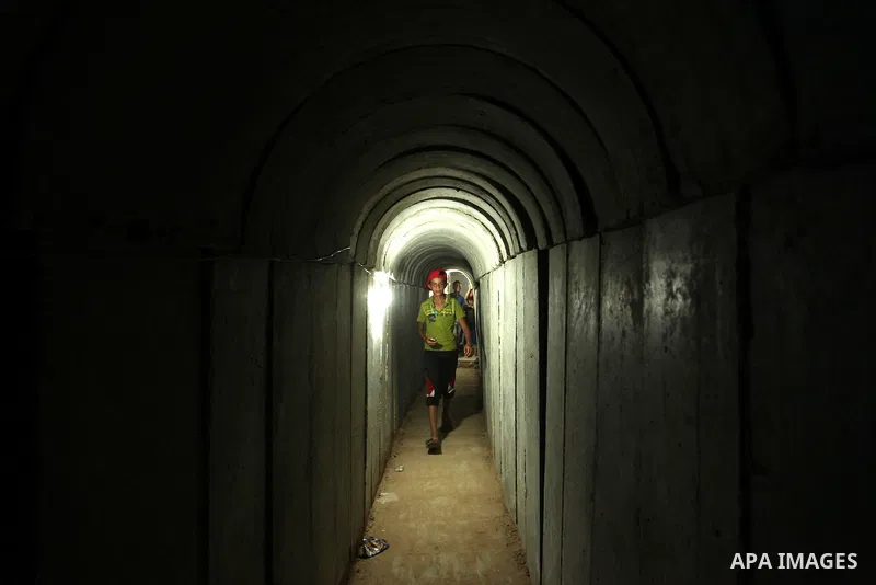 Palestinians walk inside a tunnel used for military exercises during a weapon exhibition at a Hamas-run youth summer camp, in Gaza City, on July 21, 2016. Photo by Ashraf Amra