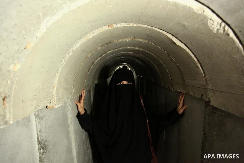 A Palestinian woman walks inside a tunnel used for military exercises during a weapon exhibition at a Hamas-run youth summer camp, in Gaza City, on July 21, 2016. Photo by Ashraf Amra