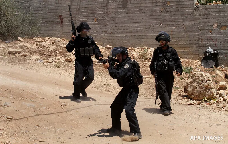 Israeli security forces aim their weapons towards Palestinian protestors during clashes following the weekly demonstration against the expropriation of Palestinian land by Israel in the village of Kfar Qaddum, near Nablu...