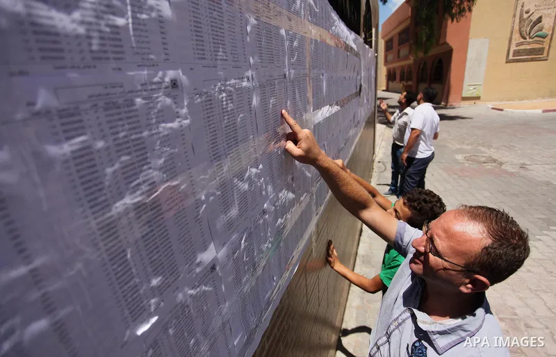 Palestinians look for their names on the registered voters' list at Voter registration centers in Gaza city, on July 23, 2016. The Palestinian Central Elections Commission (CEO) announced Saturday that voter registration...