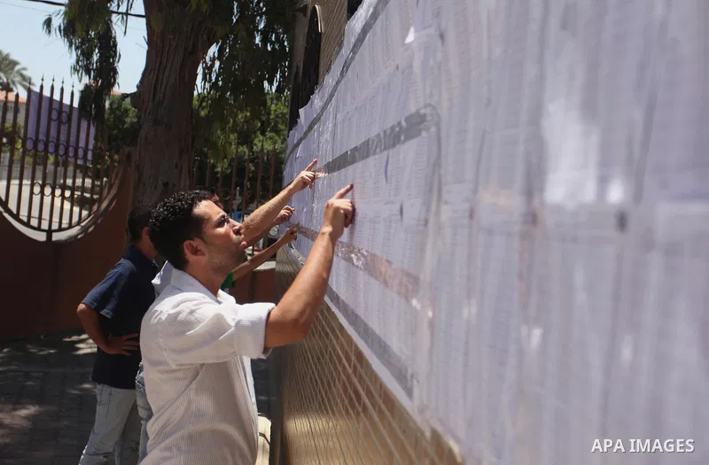 Palestinians look for their names on the registered voters' list at Voter registration centers in Gaza city, on July 23, 2016. The Palestinian Central Elections Commission (CEO) announced Saturday that voter registration...