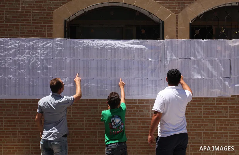 Palestinians look for their names on the registered voters' list at Voter registration centers in Gaza city, on July 23, 2016. The Palestinian Central Elections Commission (CEO) announced Saturday that voter registration...