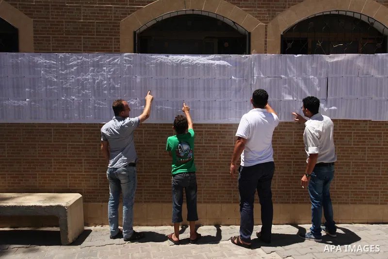 Palestinians look for their names on the registered voters' list at Voter registration centers in Gaza city, on July 23, 2016. The Palestinian Central Elections Commission (CEO) announced Saturday that voter registration...