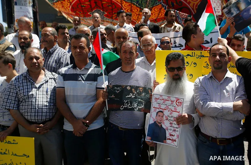 Palestinians hold placards during a protest in the West Bank city of Hebron 23 July 2016. Palestinians from all over the West bank held protest to support Palestinians prisoners Bilal Kayyed and Mohammad and Mahmoud Balb...
