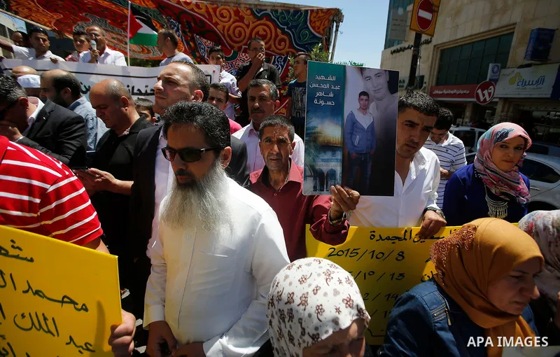Palestinians hold placards during a protest in the West Bank city of Hebron 23 July 2016. Palestinians from all over the West bank held protest to support Palestinians prisoners Bilal Kayyed and Mohammad and Mahmoud Balb...