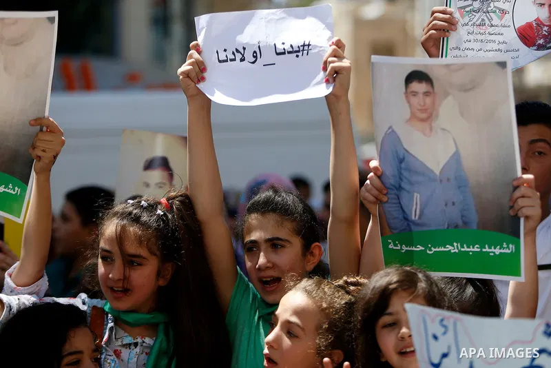 Palestinians hold placards during a protest in the West Bank city of Hebron 23 July 2016. Palestinians from all over the West bank held protest to support Palestinians prisoners Bilal Kayyed and Mohammad and Mahmoud Balb...