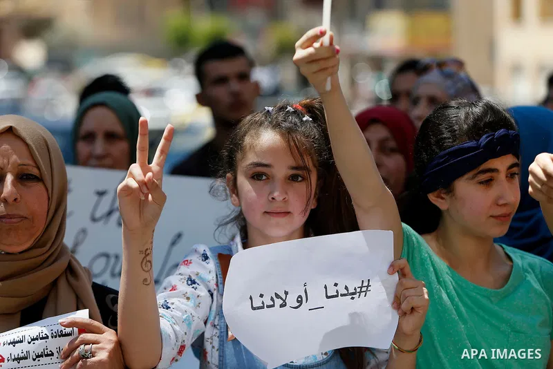 Palestinians hold placards during a protest in the West Bank city of Hebron 23 July 2016. Palestinians from all over the West bank held protest to support Palestinians prisoners Bilal Kayyed and Mohammad and Mahmoud Balb...