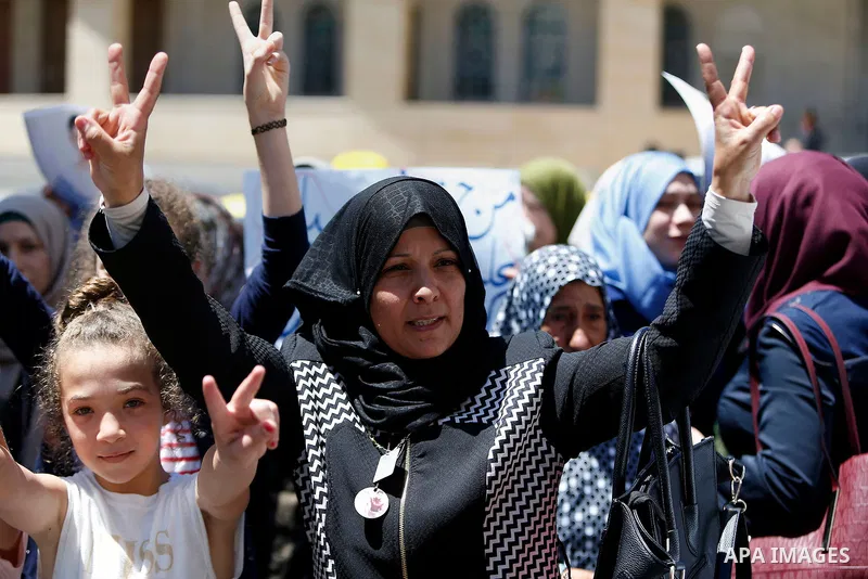 Palestinians hold placards during a protest in the West Bank city of Hebron 23 July 2016. Palestinians from all over the West bank held protest to support Palestinians prisoners Bilal Kayyed and Mohammad and Mahmoud Balb...