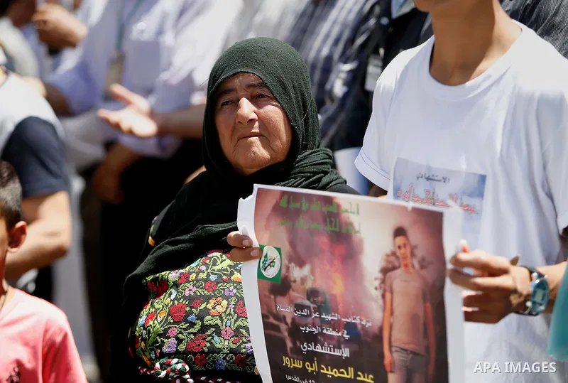 Palestinians hold placards during a protest in the West Bank city of Hebron 23 July 2016. Palestinians from all over the West bank held protest to support Palestinians prisoners Bilal Kayyed and Mohammad and Mahmoud Balb...