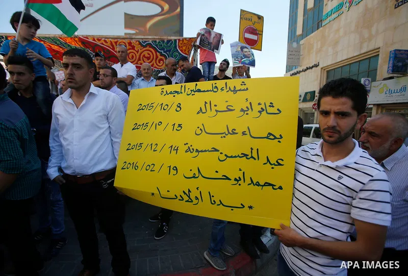 Palestinians hold placards during a protest in the West Bank city of Hebron 23 July 2016. Palestinians from all over the West bank held protest to support Palestinians prisoners Bilal Kayyed and Mohammad and Mahmoud Balb...