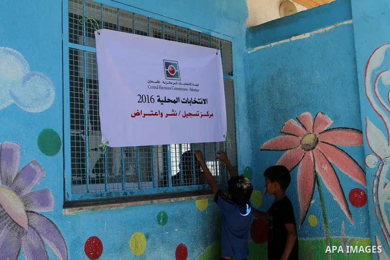 Palestinian boys play outside Voter registration centers in Rafah in the southern Gaza strip on July 23, 2016. The Palestinian Central Elections Commission (CEO) announced Saturday that voter registration centers would b...